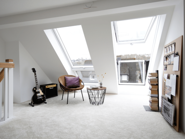 Pièce mansardée avec plafond en pente et fenêtres de toit VELUX, espace lumineux et aéré.