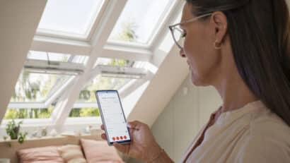 Chambre mansardée avec fenêtres de toit VELUX, lumière naturelle et décoration chaleureuse.