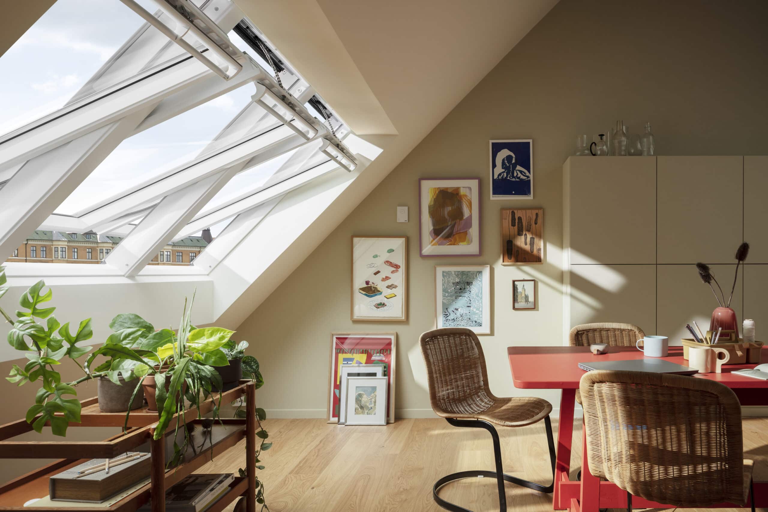 Espace de travail sous les combles avec plafond mansard&eacute; et fen&ecirc;tre de toit VELUX ouverte, lumineux et a&eacute;r&eacute;.