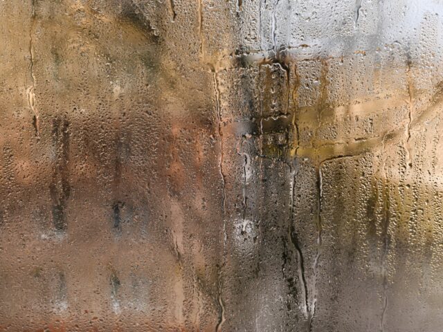 Problème de condensation : des gouttelettes d'eau se forment sur la fenêtre en raison d'un taux d'humidité élevé dans l'air. La surface vitrée reste constamment humide dans une pièce humide. Fond vitré humide.