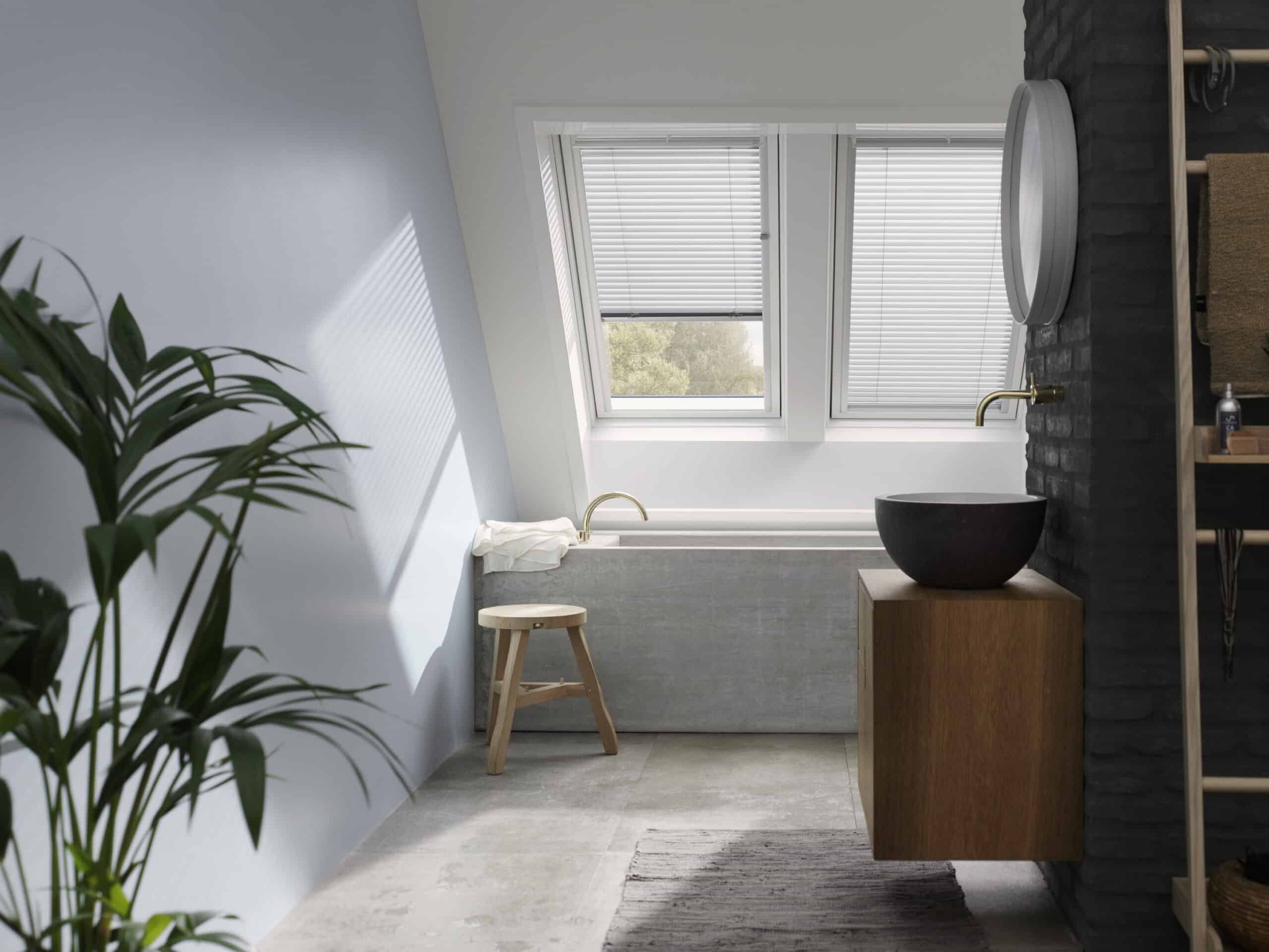 Salle de bains avec plafond mansard&eacute; et fen&ecirc;tres de toit VELUX, design moderne.