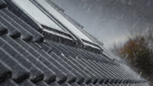 Toiture en tuiles avec fenêtres de toit VELUX fermées pendant les fortes pluies.
