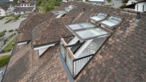 Fenêtres de toit VELUX sur un toit en tuiles, révélant un balcon.