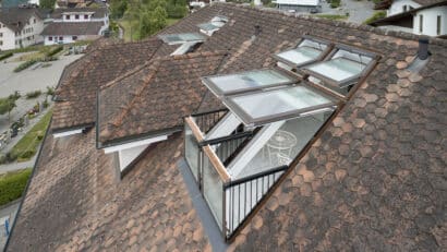 Fenêtres de toit VELUX sur un toit en tuiles, révélant un balcon.