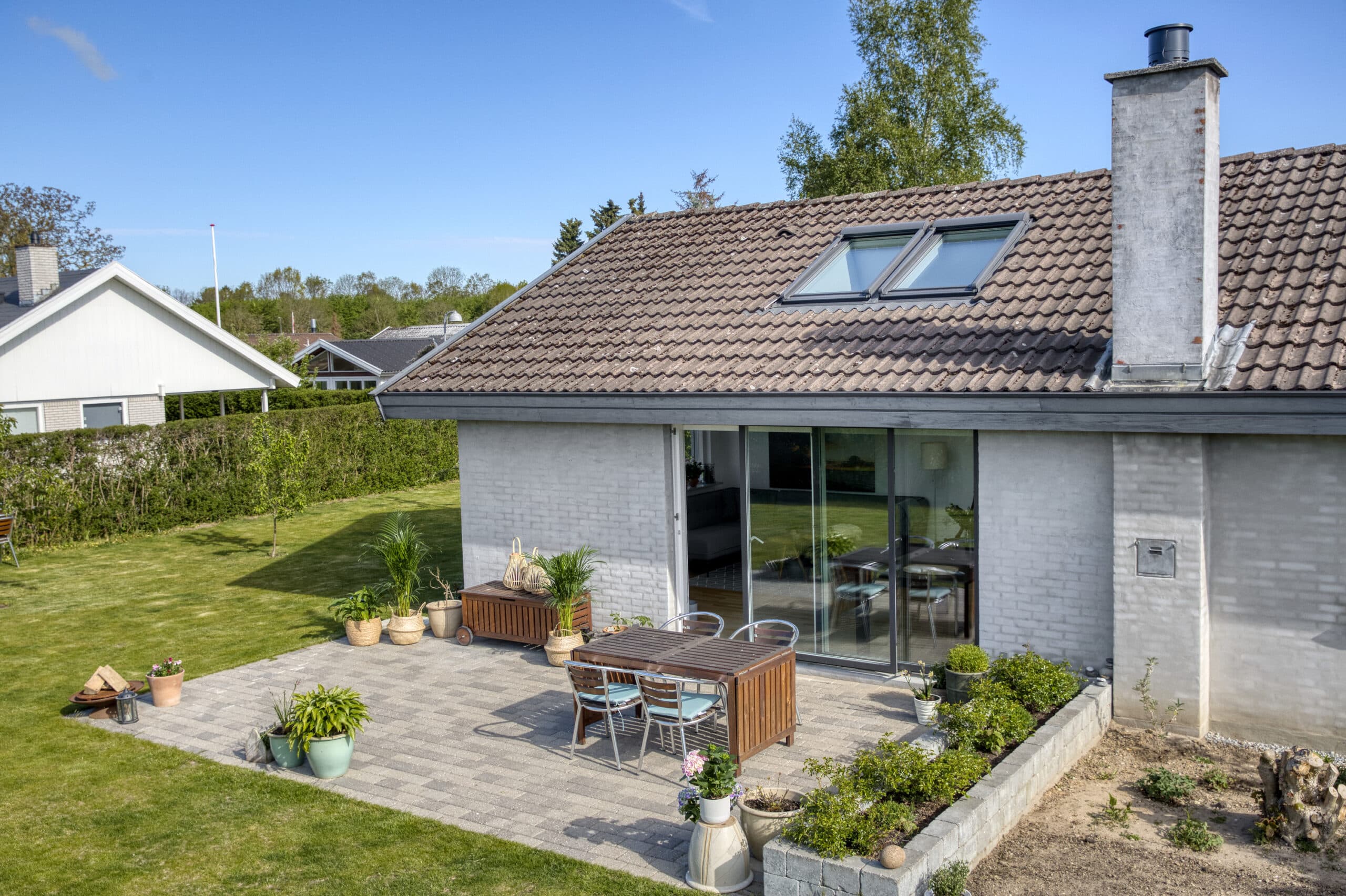 Maison individuelle avec toit en tuiles et terrasse, &eacute;quip&eacute;e de fen&ecirc;tres de toit VELUX.