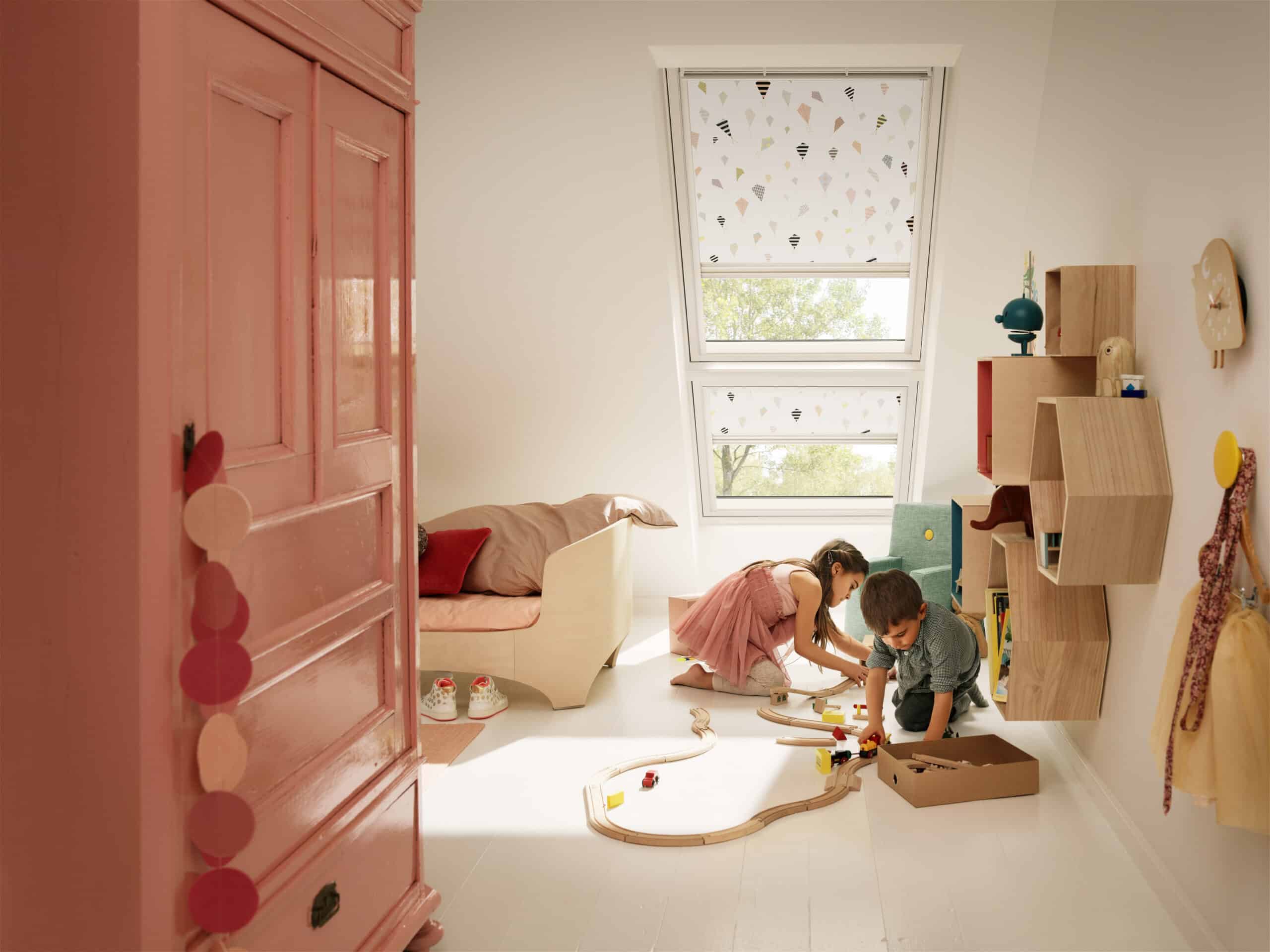 Chambre d'enfant avec une d&eacute;coration ludique et une fen&ecirc;tre de toit VELUX, laissant entrer la lumi&egrave;re naturelle.