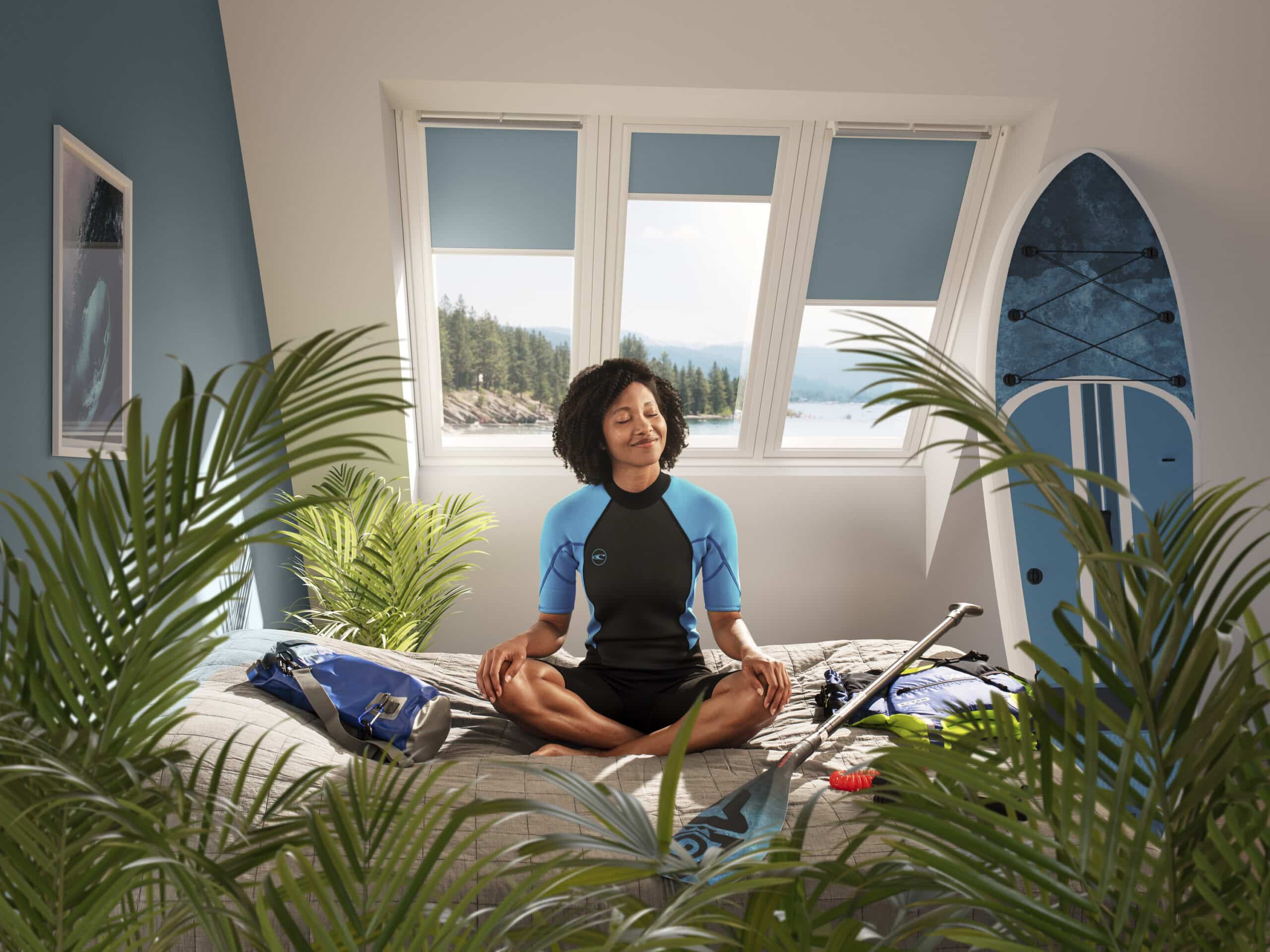 Pi&egrave;ce mansard&eacute;e avec fen&ecirc;tre de toit VELUX, planche de surf et plantes.