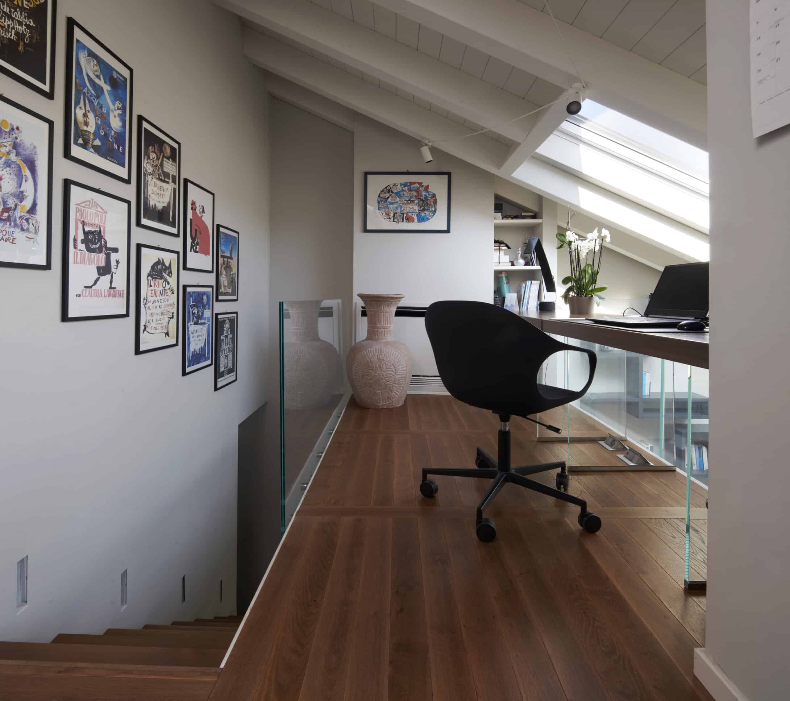 Bureau aménagé dans les combles avec plafond mansardé et fenêtre de toit VELUX, décoration moderne.