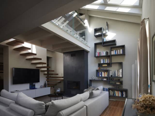 Salon mansardé avec plafond en pente et fenêtre de toit VELUX, décoration moderne.