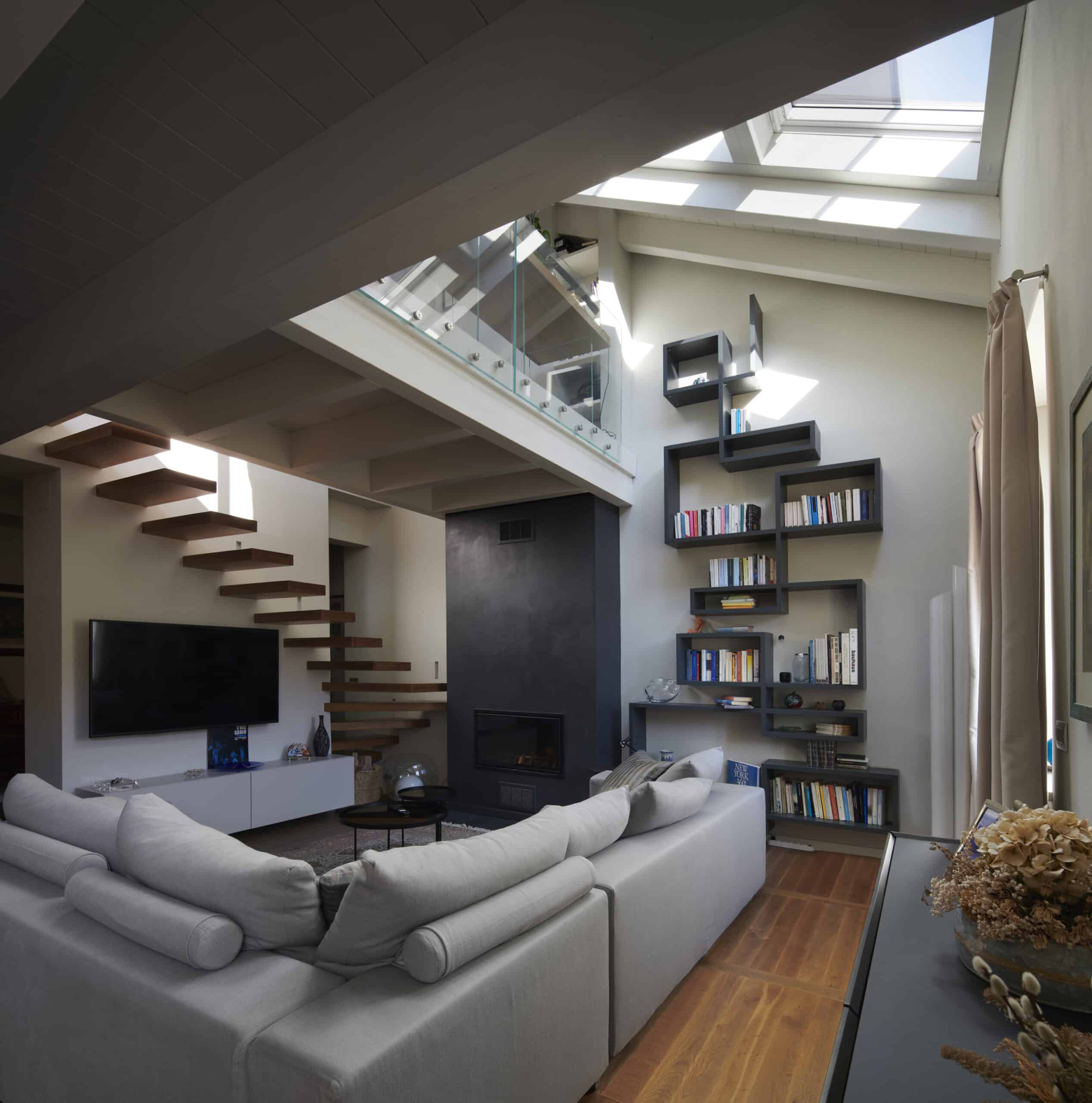 Salon mansardé avec plafond en pente et fenêtre de toit VELUX, décoration moderne.