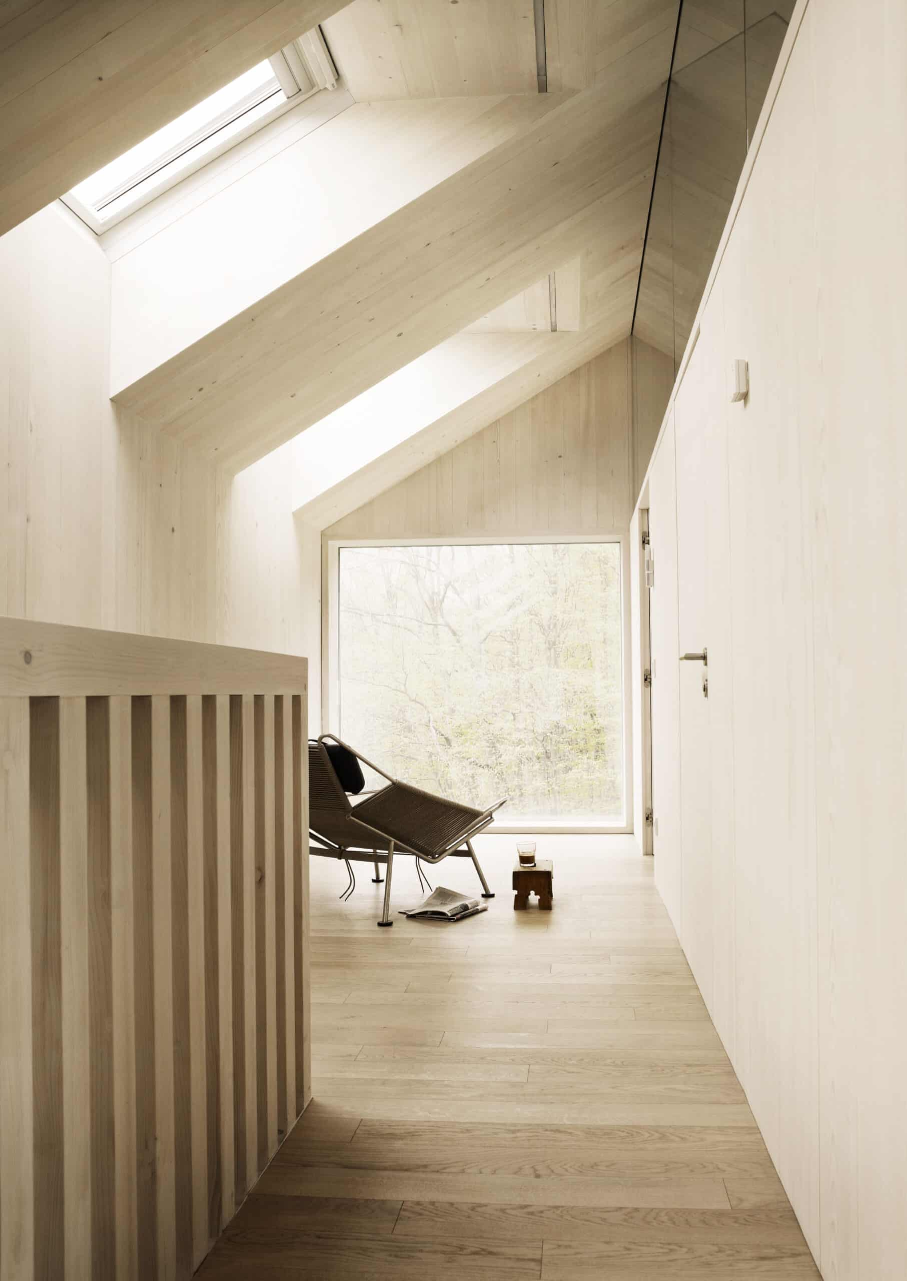 Pièce mansardée moderne avec plafond mansardé et fenêtre de toit VELUX.