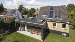 Maison moderne avec panneaux solaires et extension à toit plat.