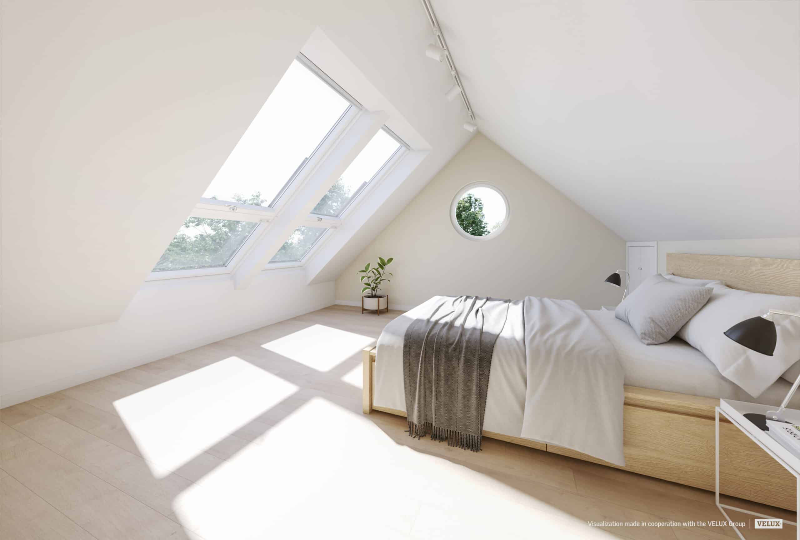 Chambre mansardée avec plafond en pente, grandes fenêtres de toit VELUX et un lit confortable.