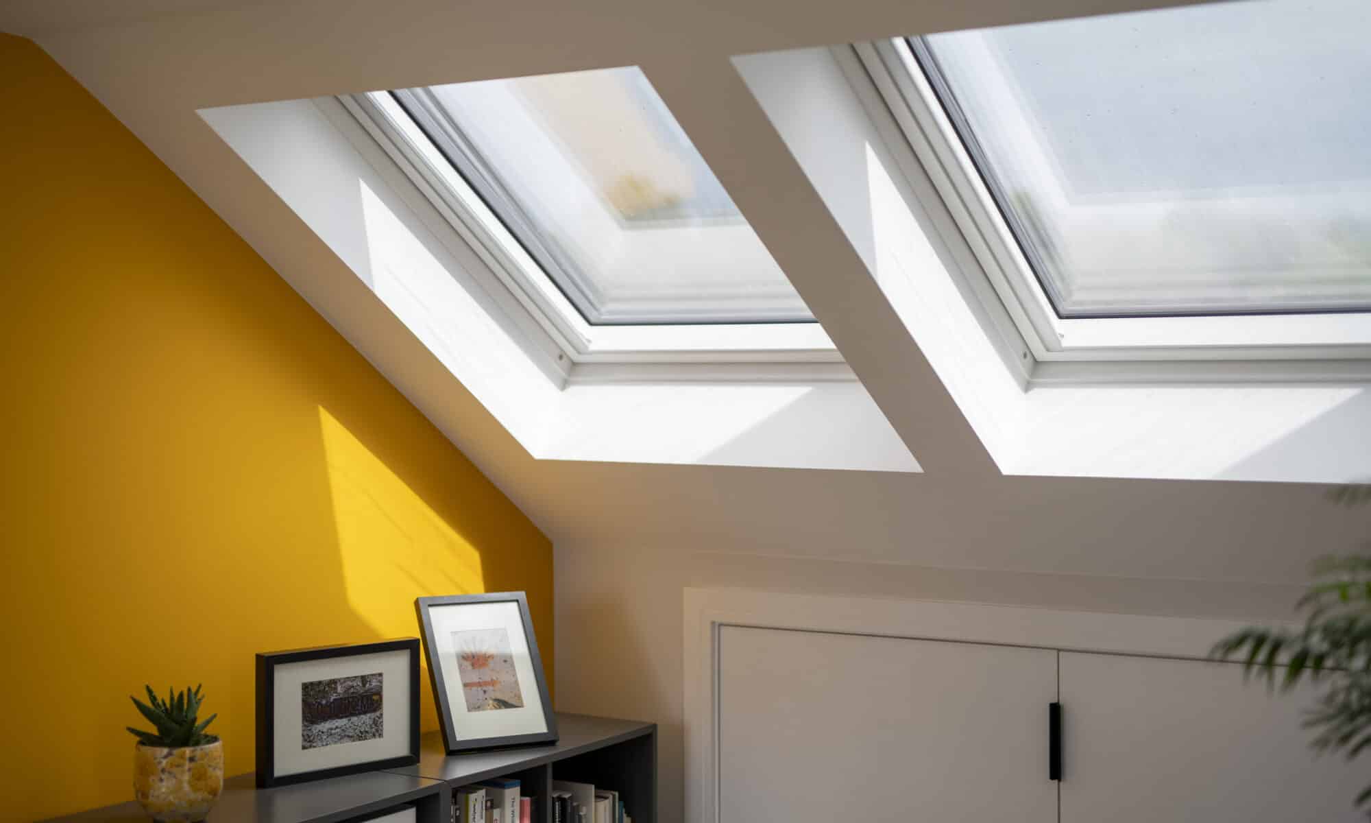 Pièce mansardée avec plafond en pente et fenêtres de toit VELUX, lumineuse et aérée.