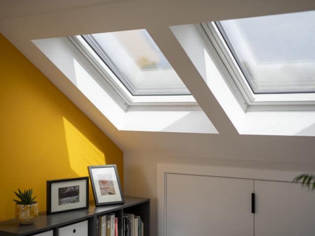 Pièce mansardée avec plafond en pente et fenêtres de toit VELUX, lumineuse et aérée.