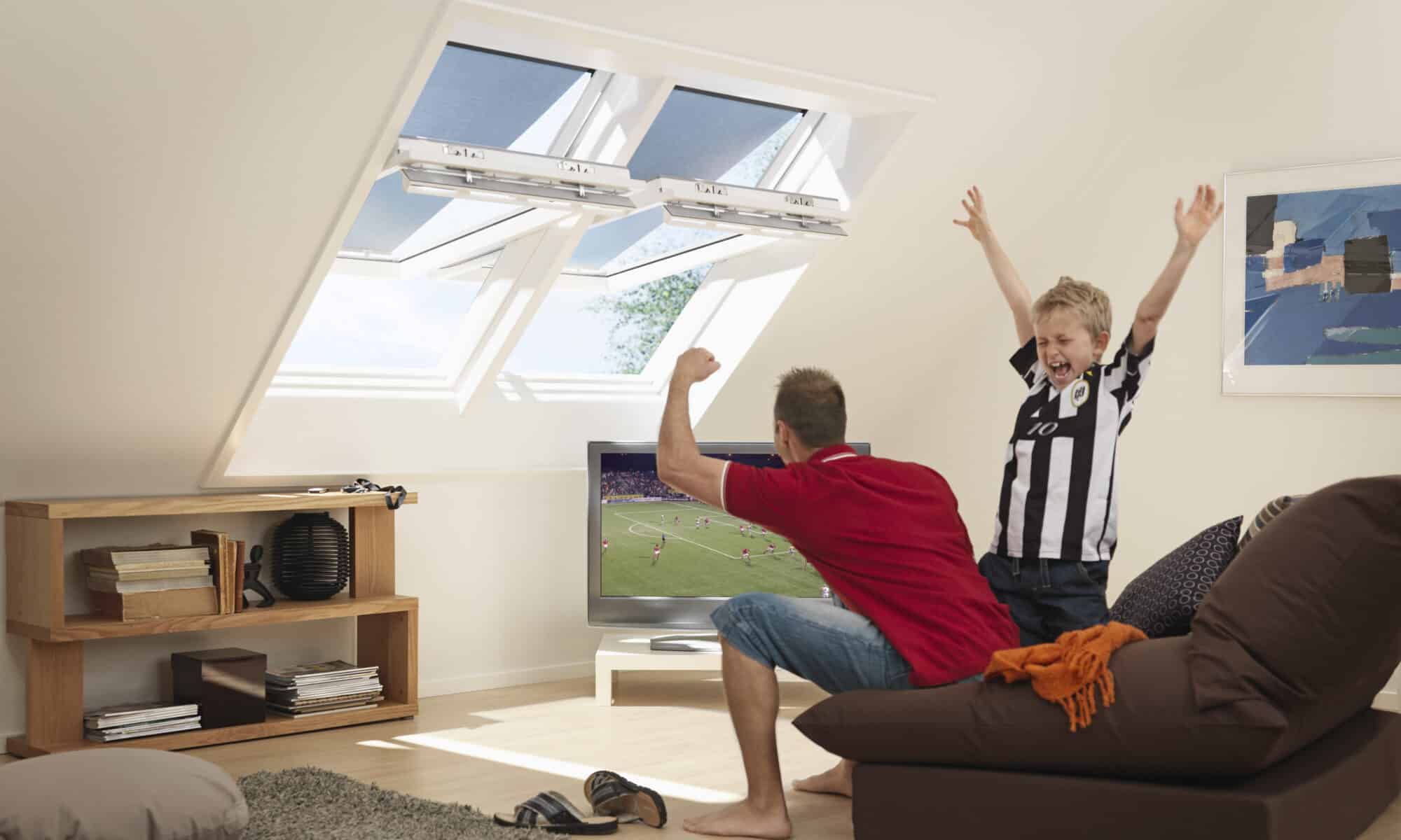 Pièce mansardée avec plafond mansardé, fenêtres de toit VELUX et coin salon