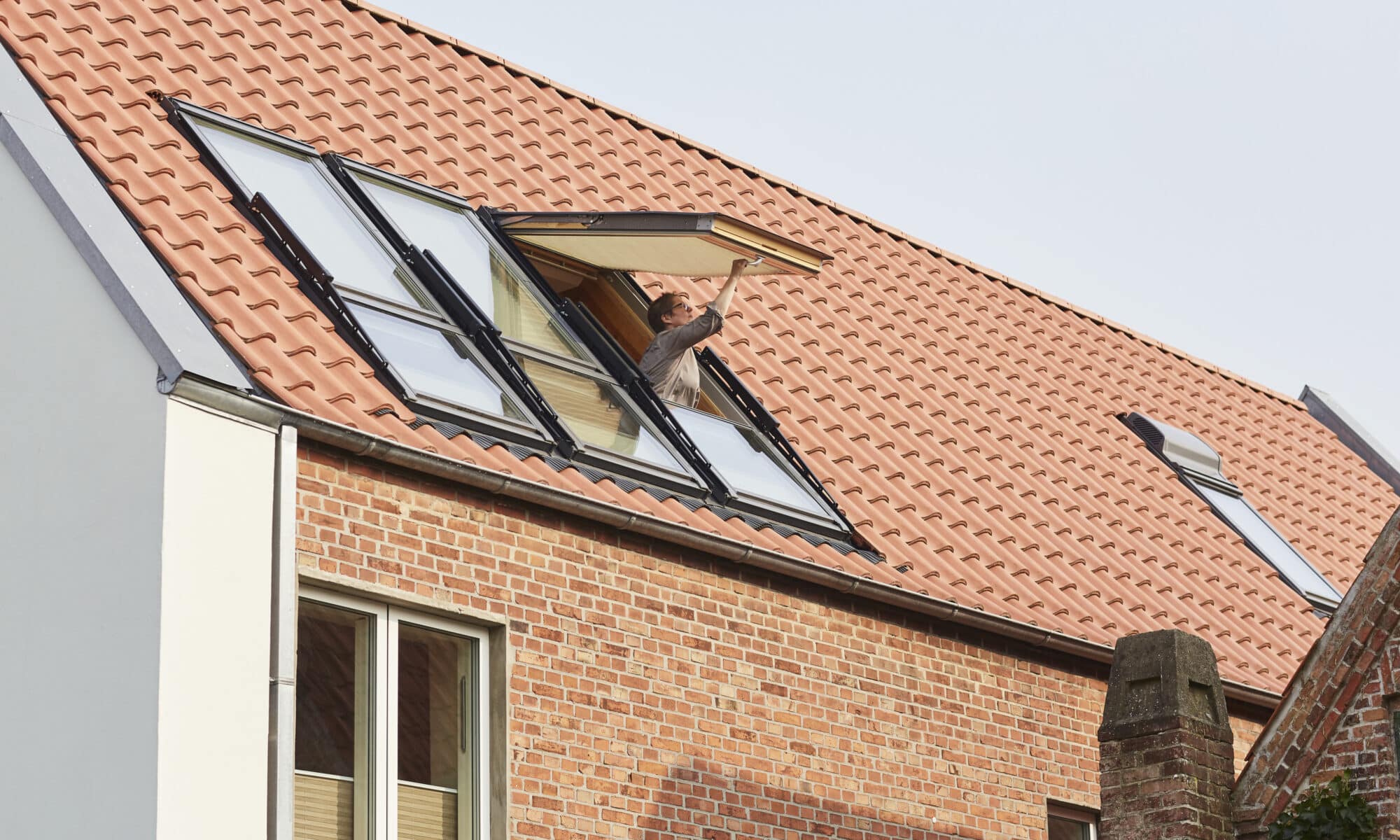 Maison au design moderne avec toit en tuiles rouges et fenêtres de toit VELUX.