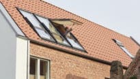 Maison au design moderne avec toit en tuiles rouges et fenêtres de toit VELUX.