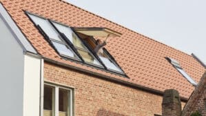 Maison au design moderne avec toit en tuiles rouges et fenêtres de toit VELUX.