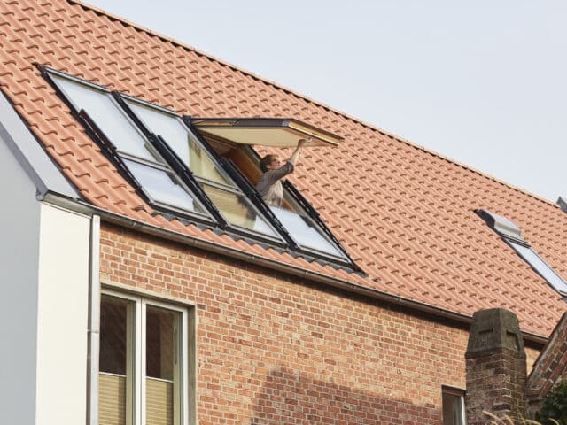 Maison au design moderne avec toit en tuiles rouges et fenêtres de toit VELUX.