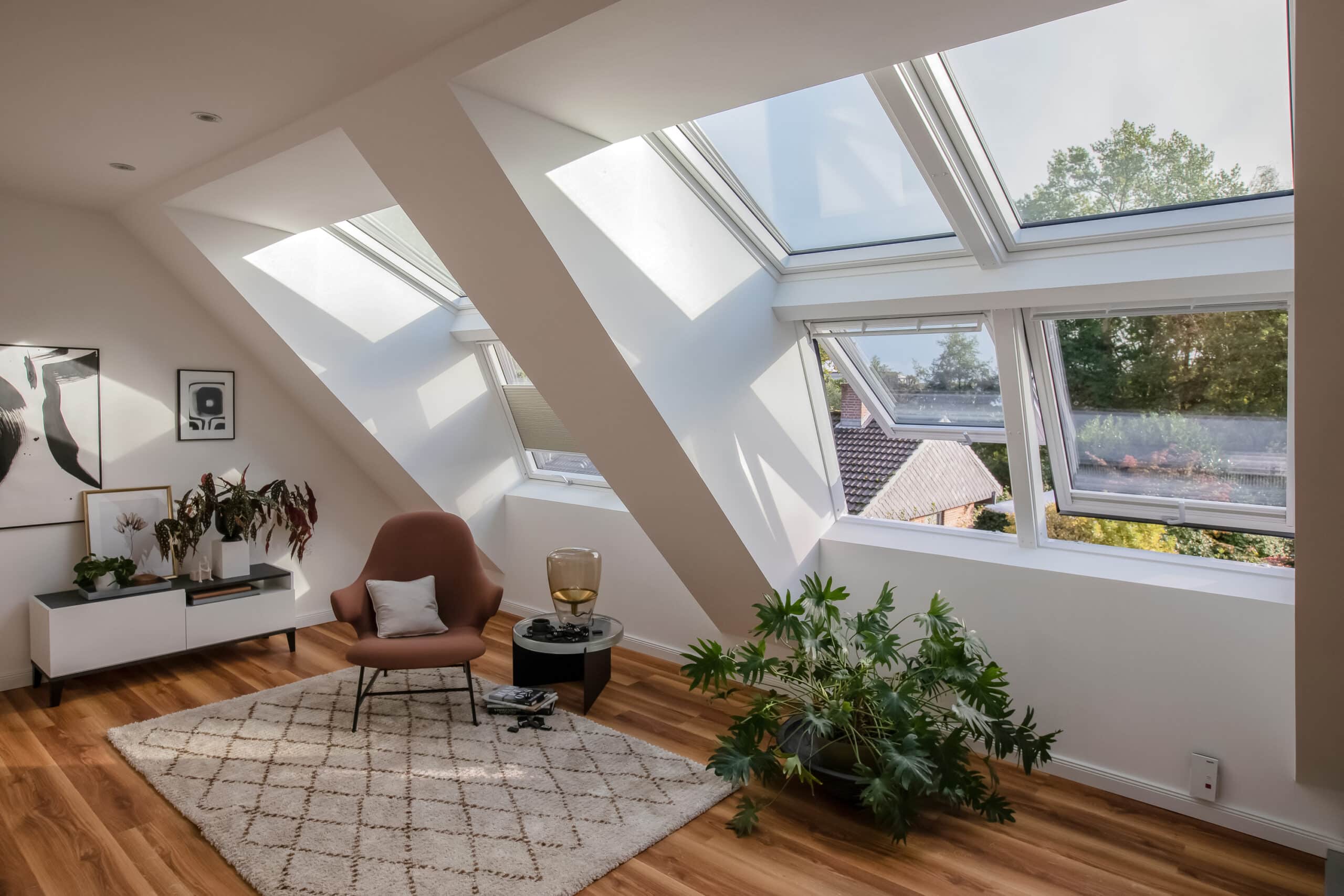 Espace de vie sous combles avec plafond en pente et fen&ecirc;tres de toit VELUX, baign&eacute; de lumi&egrave;re naturelle.