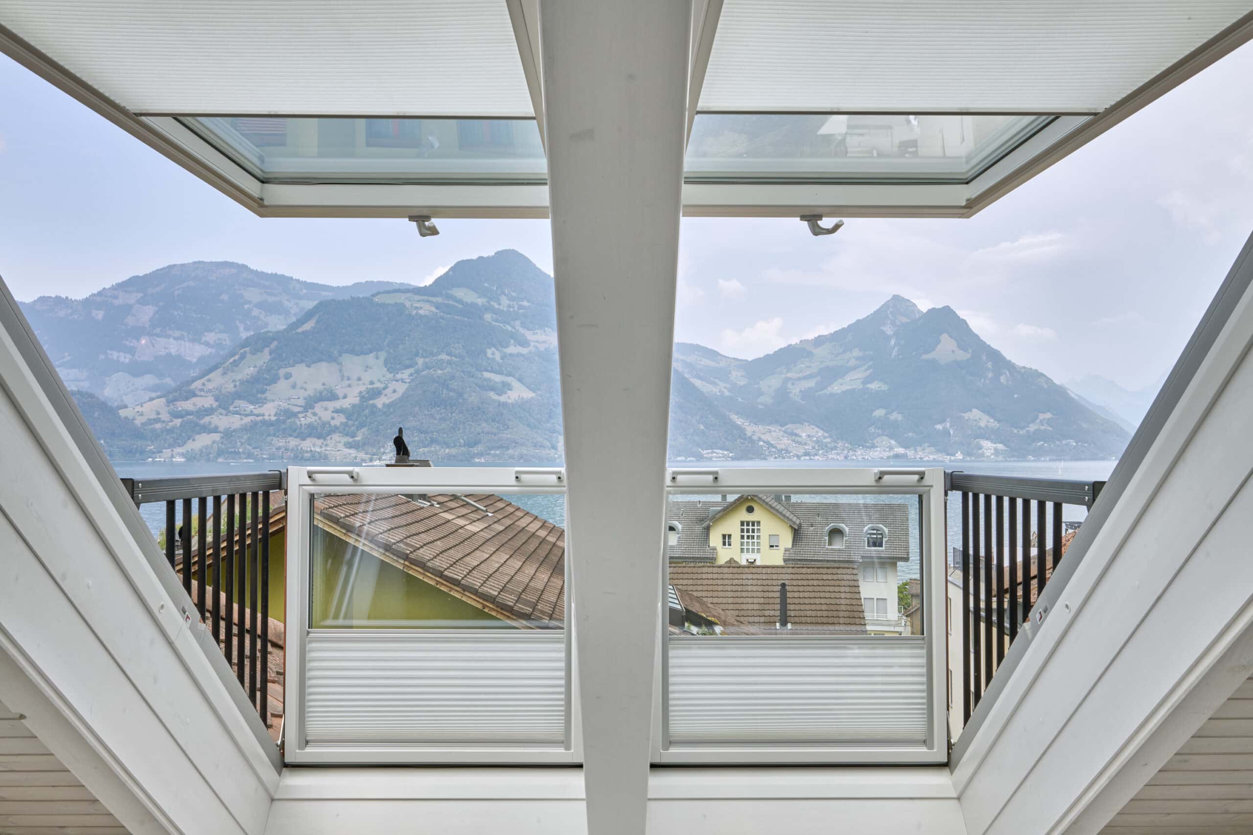 Chambre mansardée équipée d'une fenêtre de toit VELUX, avec vue sur la montagne.