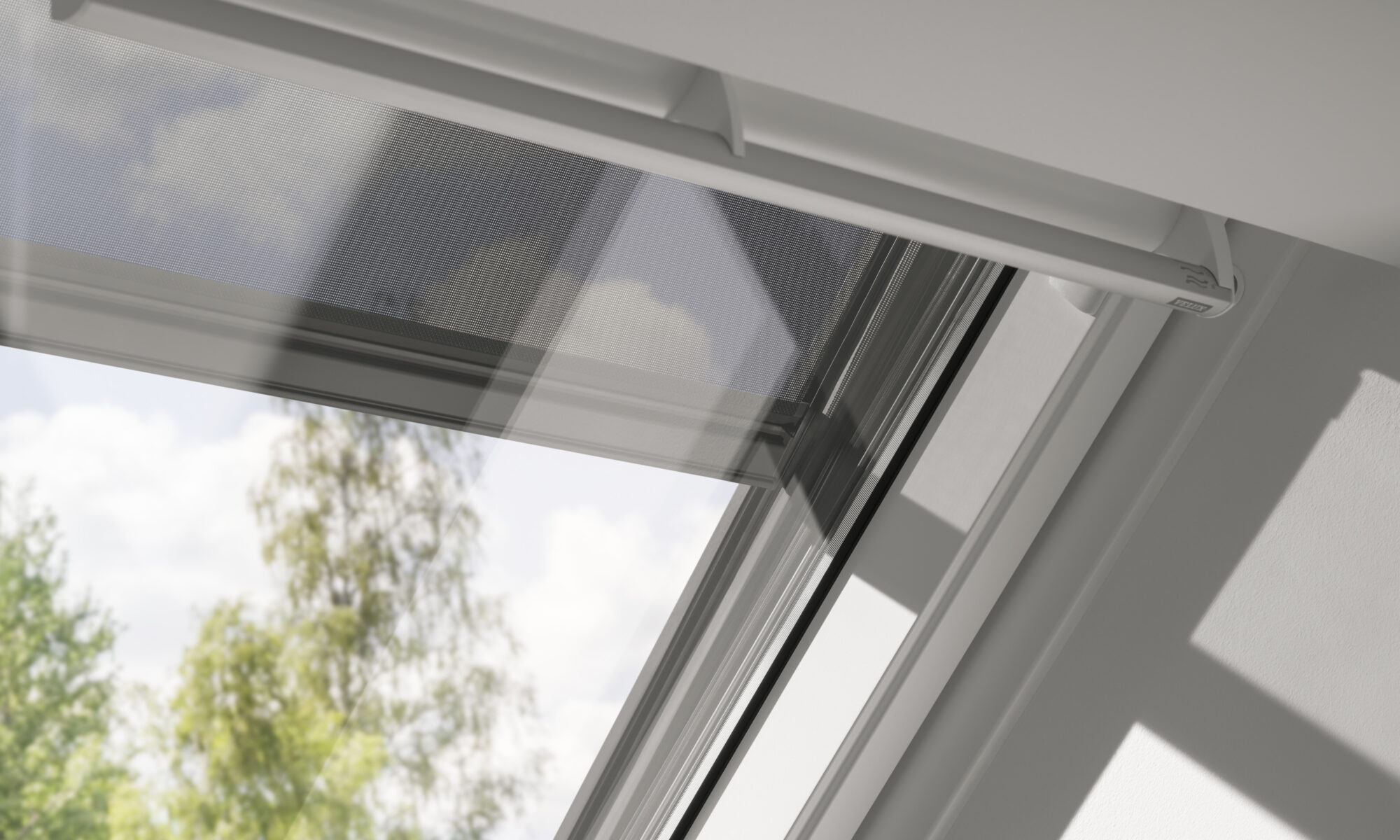 Fenêtre de toit VELUX légèrement entrouverte, vue sur les arbres et le ciel à l'extérieur.