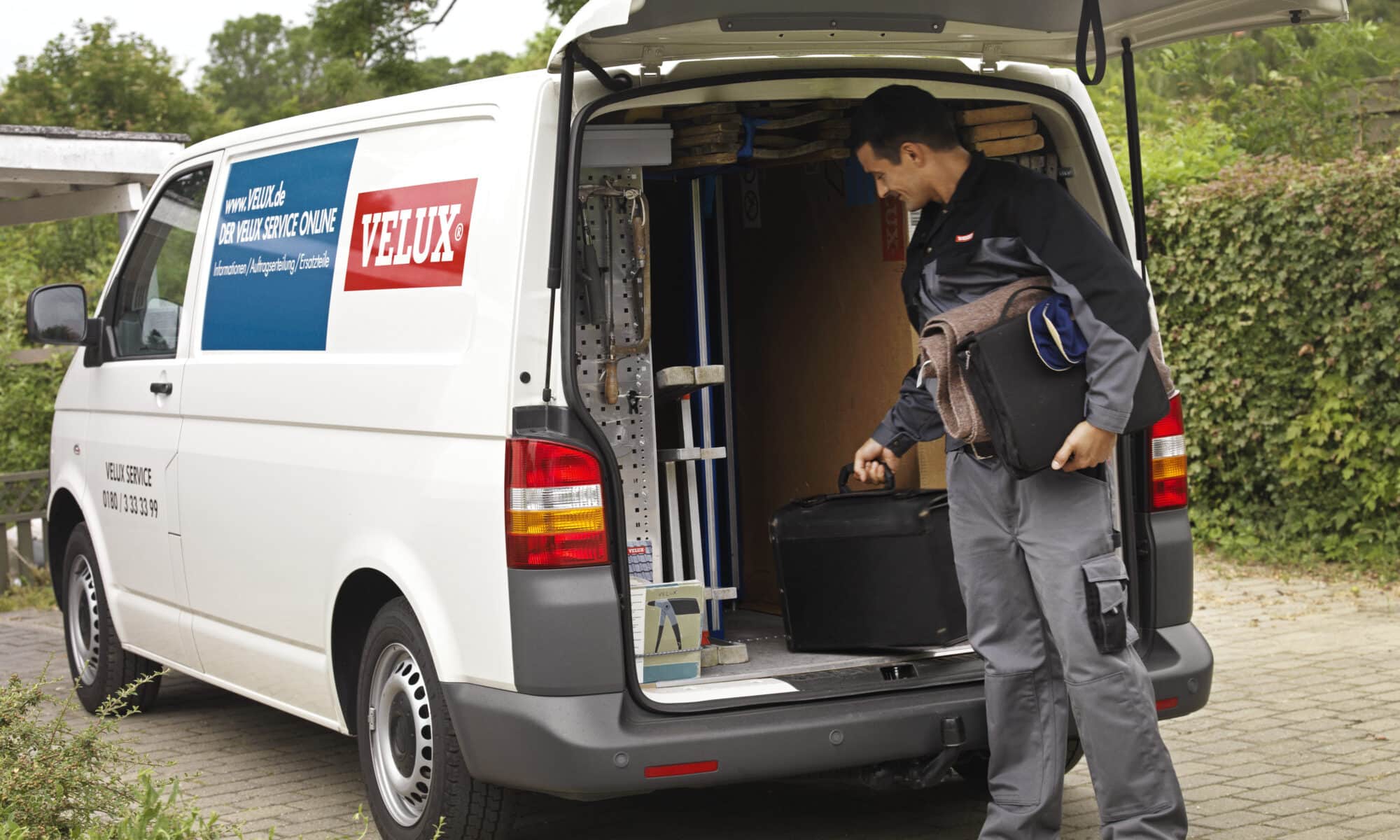 Service VELUX avec un technicien se préparant à intervenir pour remplacer une fenêtre de toit.