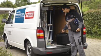 Service VELUX avec un technicien se préparant à intervenir pour remplacer une fenêtre de toit.