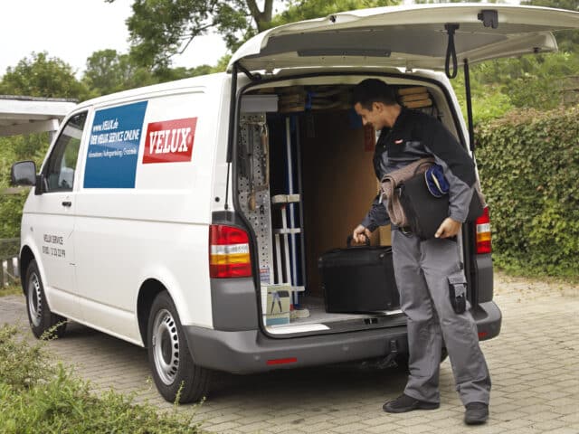 Service VELUX avec un technicien se préparant à intervenir pour remplacer une fenêtre de toit.