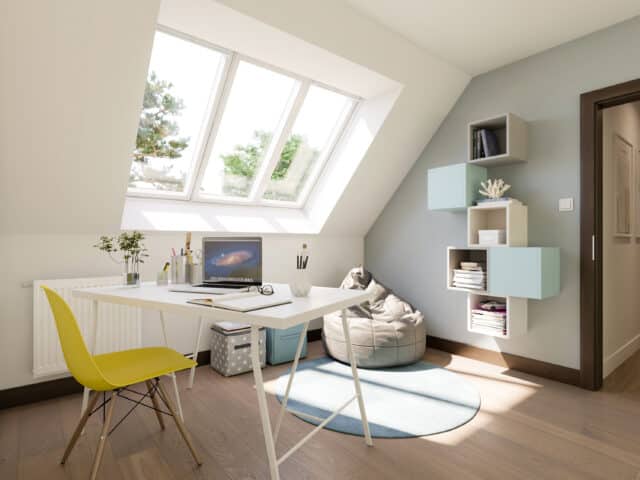 Bureau à domicile sous combles avec plafond en pente et fenêtre de toit VELUX, lumineux et aéré.