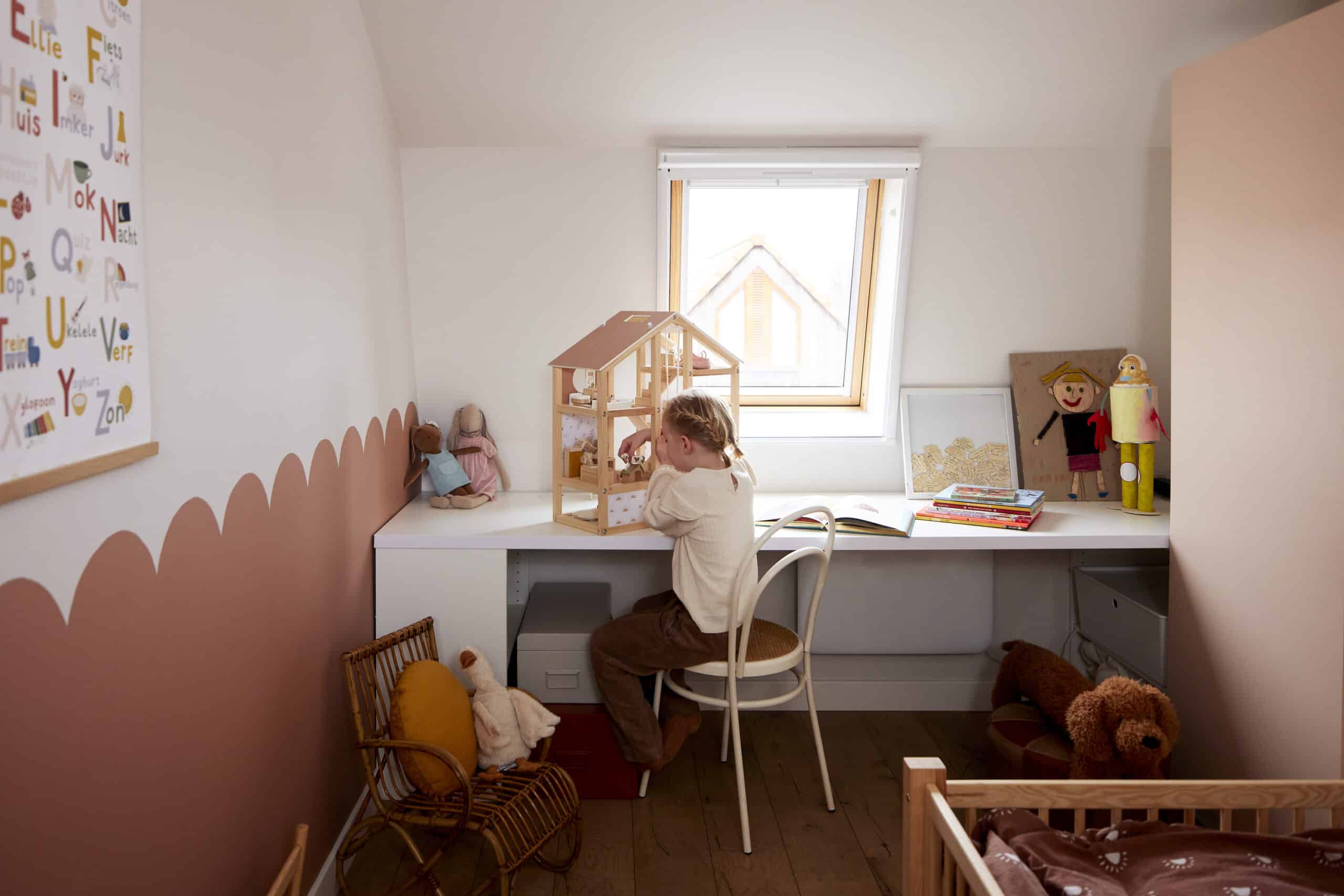 Chambre d'enfant avec plafond mansard&eacute; et fen&ecirc;tre de toit VELUX, maison de poup&eacute;e et jouets.